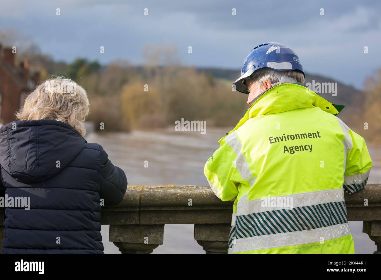 Environment Agency worker talks to a local resident on the bridge of the River Severn in Bewdley after major flooding incident, February 2022. Stock Photo