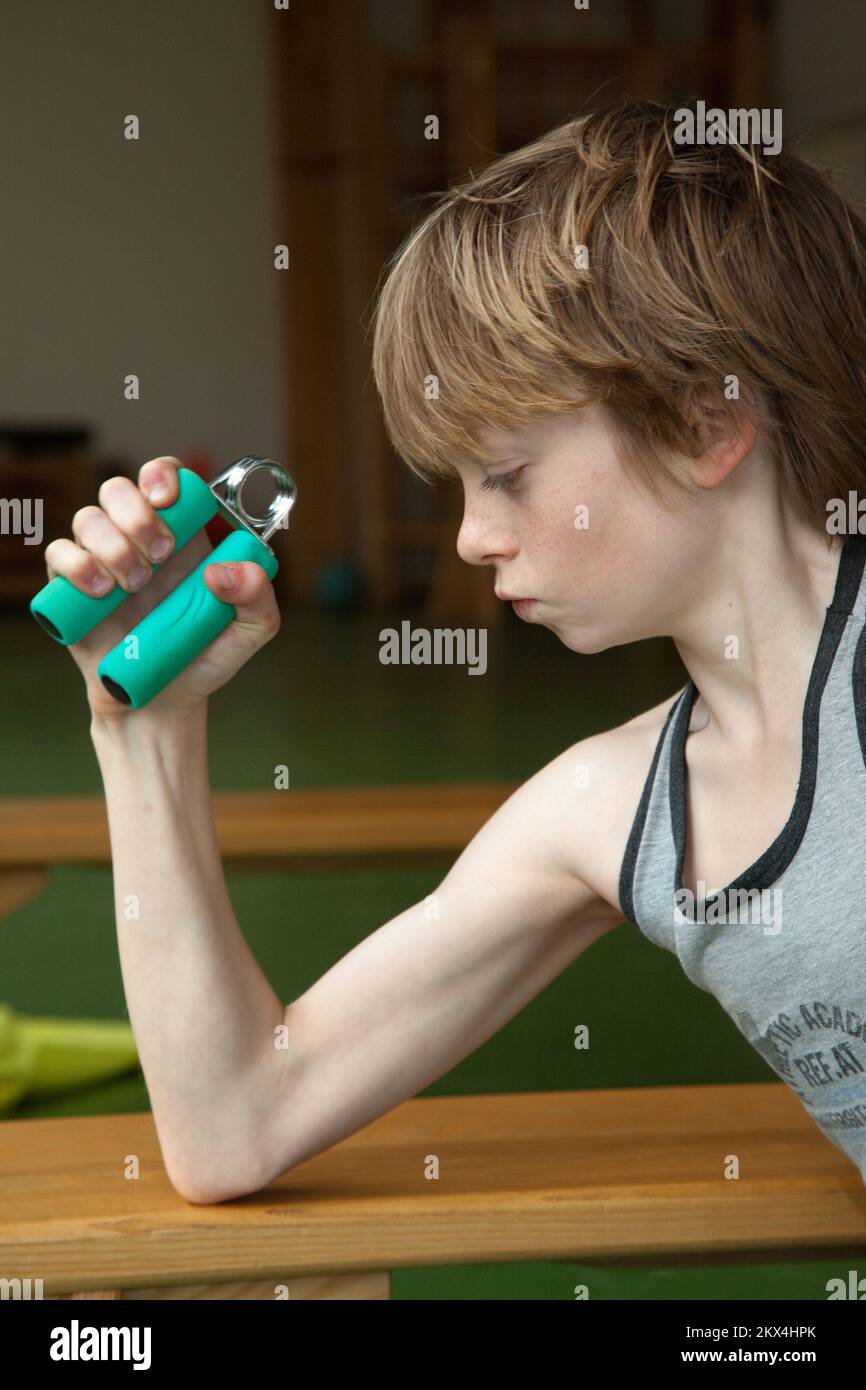 Boy squeezes a hand spring as training Stock Photo - Alamy