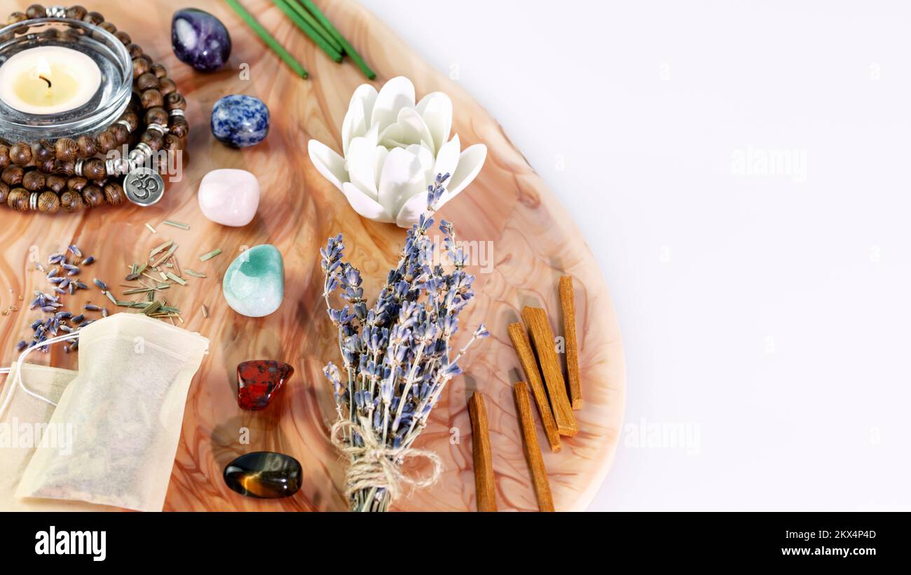 Self-care, energy healing composition with rosary beads, aroma sticks, chakra stones, sandalwood sticks and candle on pink marble podium with copy spa Stock Photo