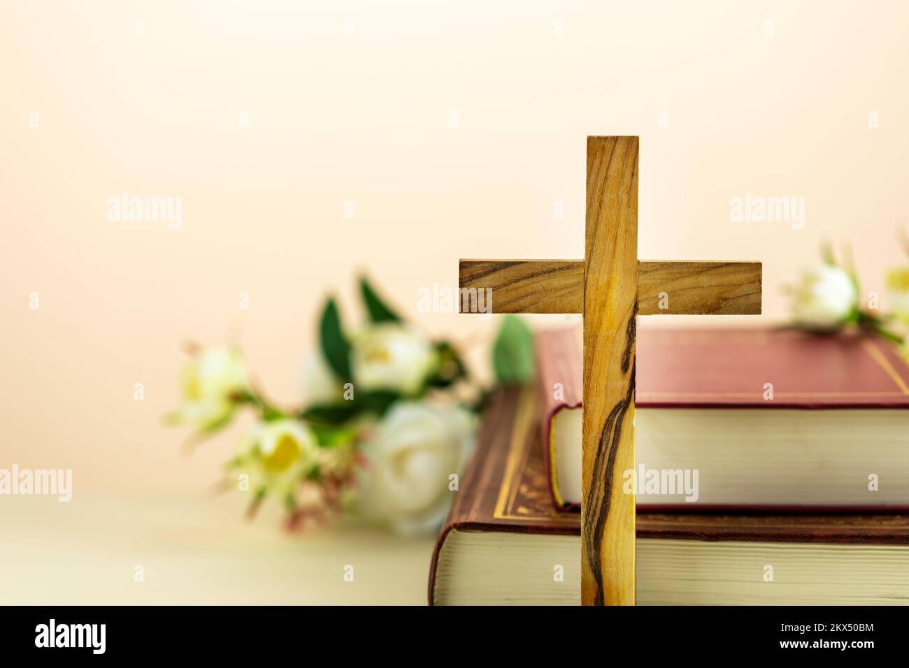 Religion composition with wooden cross with closed red Christian bibles