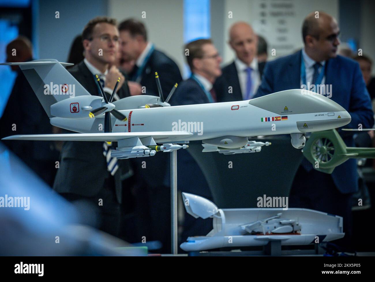 Berlin, Germany. 30th Nov, 2022. Visitors at the Berlin Security Conference (BSC) walk by a model of Airbus' Eurodrone, the joint European Medium Altitude Long Endurance Remotely Piloted Aircraft System (MALE RPAS) project, in the exhibit hall. Credit: Michael Kappeler/dpa/Alamy Live News Stock Photo