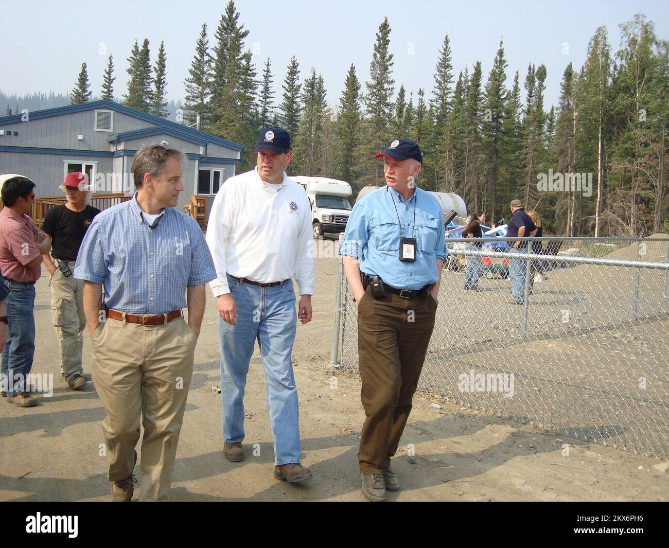 Flooding   Winter Storm - Eagle, Alaska, August 5, 2009   Alaska Governor Sean Parnell (left) is briefed by FEMA Federal Coordinating Officer Doug Mayne (center) and FEMA Operations Chief Robert Purcell (right) at the site where a new village clinic will be built in Eagle, AK. The old clinic was destroyed by the ice and flood of April 28 to May 31, 2009. - Jack Heesch/FEMA. Alaska Flooding and Ice Jams. Photographs Relating to Disasters and Emergency Management Programs, Activities, and Officials Stock Photo