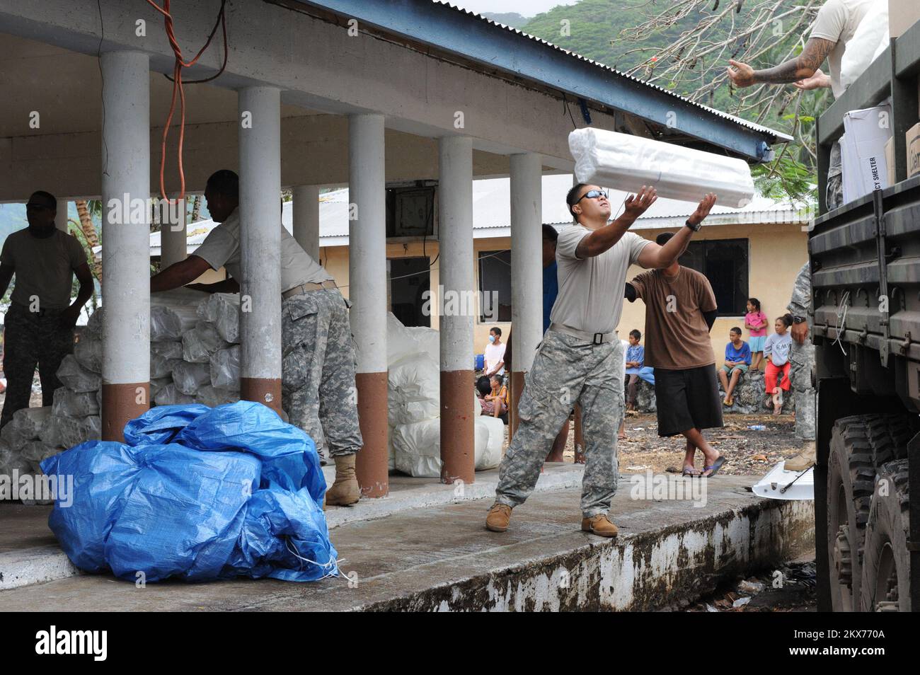 Earthquake   Tsunami - Asili, American Samoa, October 7, 2009   Members of Bravo Company, 100th Battalion, 442nd Infantry off-load much needed humanitarian supplies. American Samoa officials asked FEMA to establish this distribution center in the village of Asili to help the local community. David Gonzalez/FEMA. American Samoa Earthquake, Tsunami, and Flooding. Photographs Relating to Disasters and Emergency Management Programs, Activities, and Officials Stock Photo