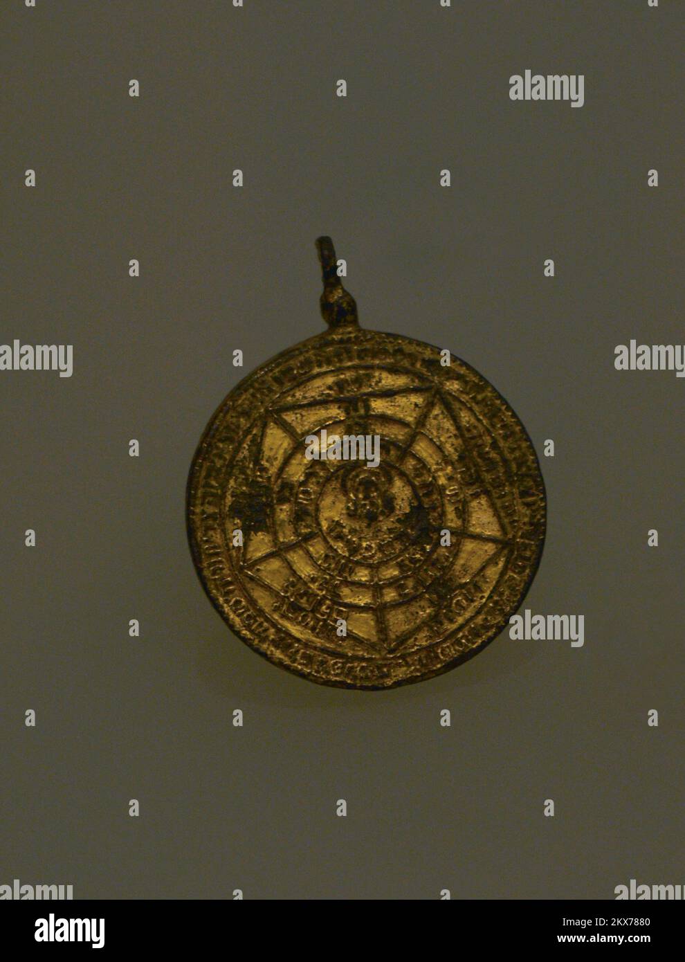 Amulet with Hebrew inscriptions. 15th-16th centuries. Obverse depicting Christ in a pentagon. It was used by Christians who travelled across the Mediterranean on their way to the Holy Land. Bronze with gold plating. Found in the Church of San Pedro (Cuenca, Spain). Sephardic Museum. Toledo. Castile-La Mancha. Spain. Stock Photo