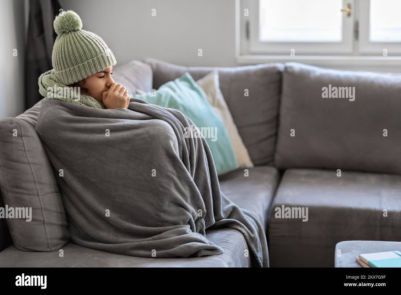Energy Crisis. Portrait Of Woman Covered In Warm Blanket Sitting On Couch Stock Photo