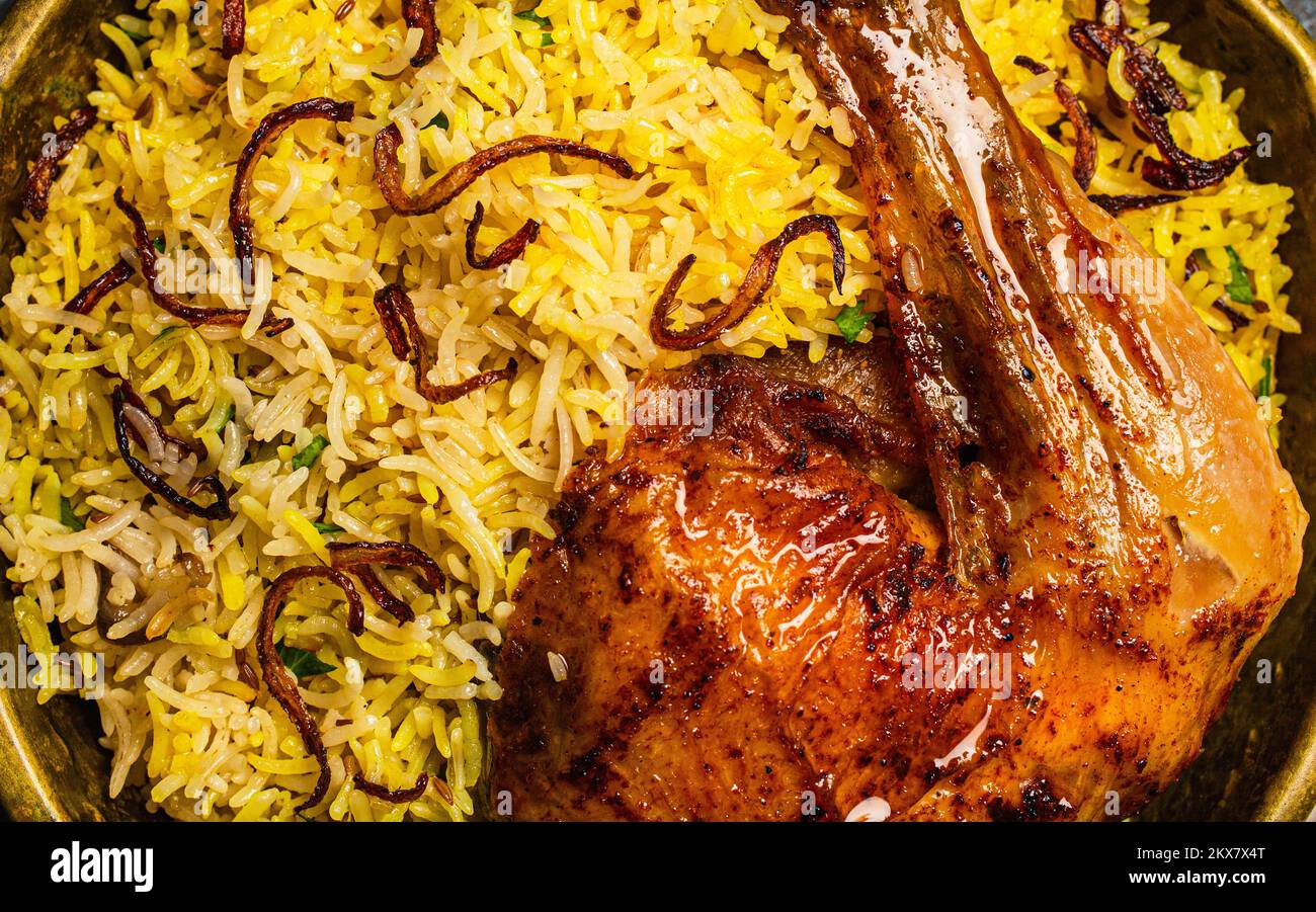 Close up macro of delicious Indian dish Biryani chicken leg with basmati rice Stock Photo