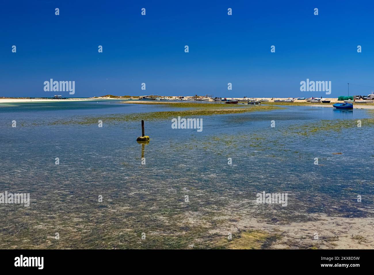 View of boats in the bay at low tide on the beach in the Mediterranean Sea on the island of Djerba, Tunisia Stock Photo