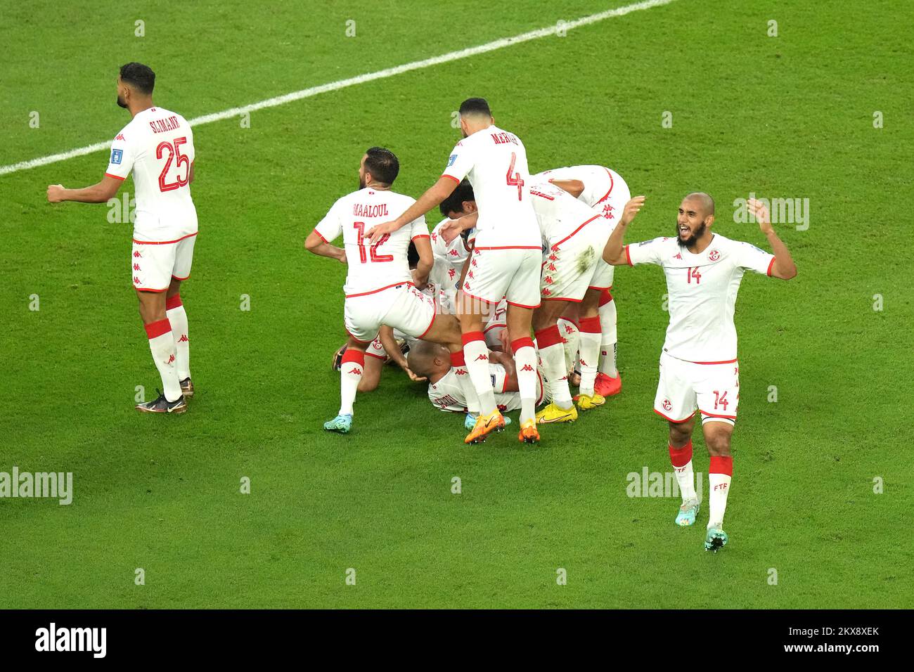 Tunisia's Wahbi Khazri (hidden) celebrates scoring their side's first goal of the game with team-mates during the FIFA World Cup Group D match at the Education City Stadium in Al Rayyan, Qatar. Picture date: Wednesday November 30, 2022. Stock Photo