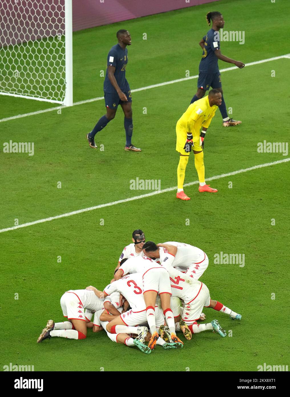 Tunisia's Wahbi Khazri (hidden) celebrates scoring their side's first goal of the game with team-mates as France players look dejected during the FIFA World Cup Group D match at the Education City Stadium in Al Rayyan, Qatar. Picture date: Wednesday November 30, 2022. Stock Photo