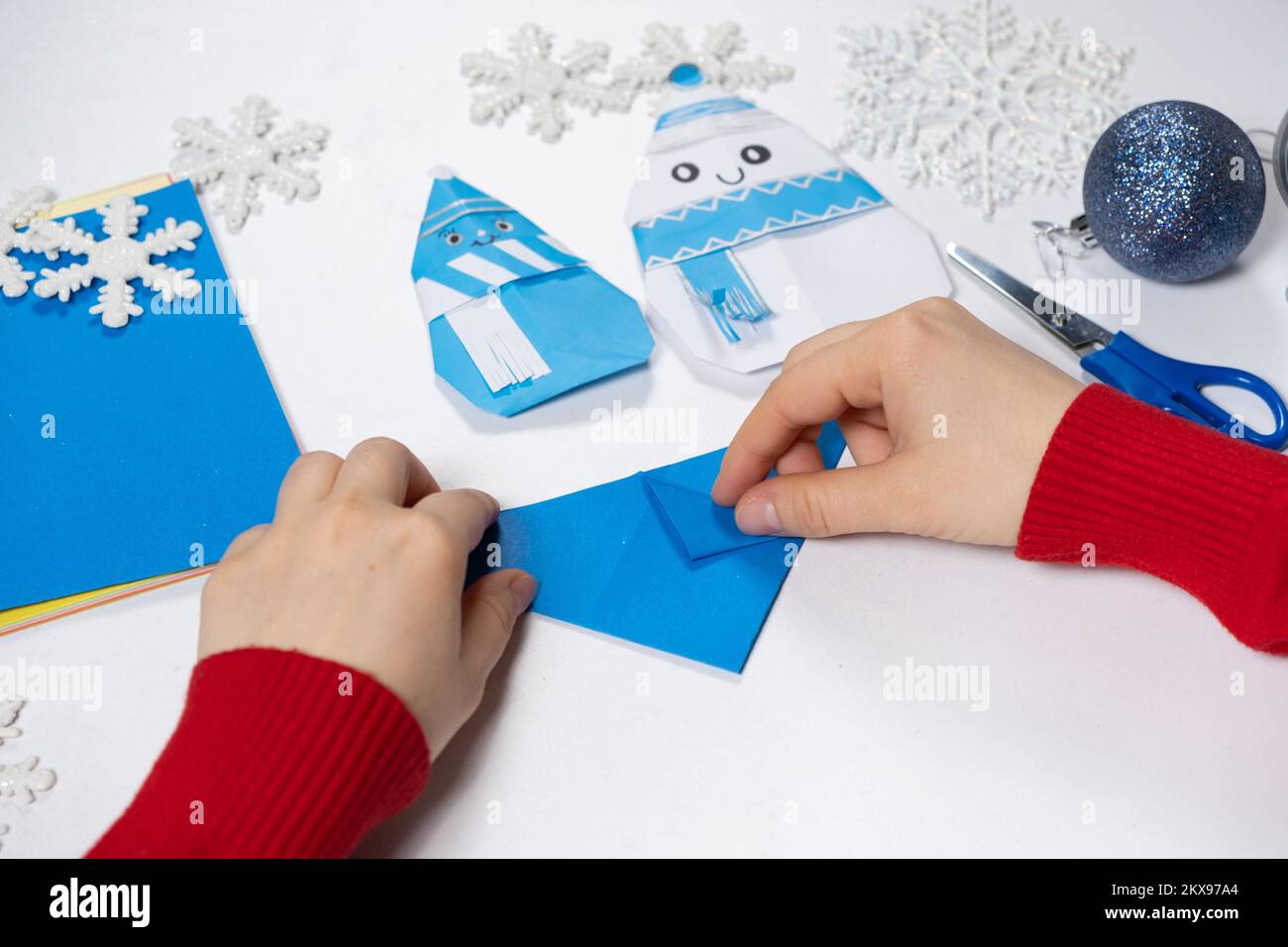 Creation of origami crafts from paper for Christmas and New Year, figurine of snowmen. Stock Photo