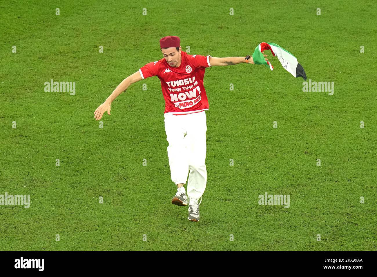A pitch invader with a t-shirt that reads 'Tunisia Your Time is Now!' runs onto the pitch while holding during the FIFA World Cup Group D match at the Education City Stadium in Al Rayyan, Qatar. Picture date: Wednesday November 30, 2022. Stock Photo