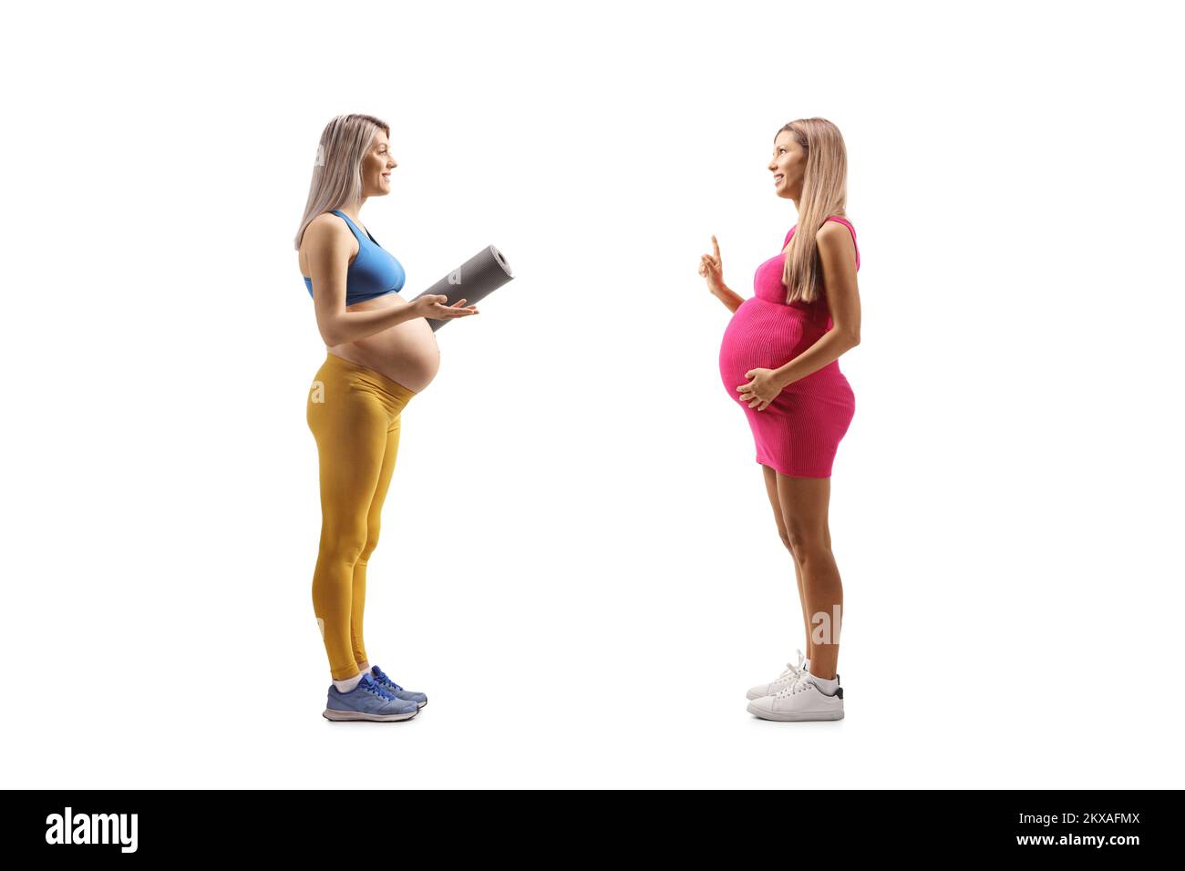 Pregnant woman in sportswear with an exercise mat having a conversation with another pregnant woman isolated on white background Stock Photo