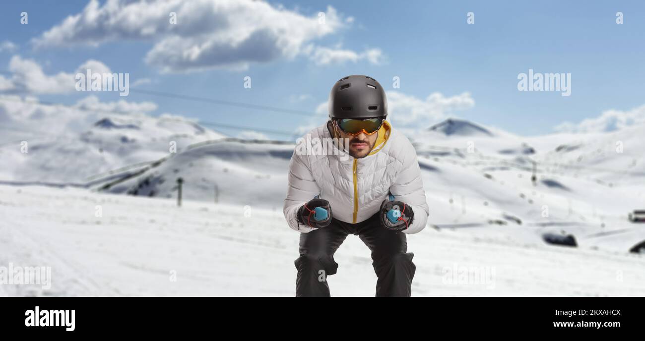 Man skiing on a snowy slope in a ski resort Stock Photo