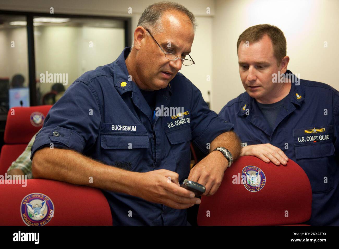 Flooding   Hurricane/Tropical Storm   Severe Storm - St. Thomas, US Virgin Islands, August 30, 2010   Coast Guard Marine Safety Supervisor, LCDR Daniel Buchsbaum looks at an updated situation report on Hurricane Earl on his blackberry with Coast Guard Marine Science Technician Chief James Carew at the Virgin Islands Territorial Emergency Management Agency (VITEMA) Emergency Operations Center in St. Thomas. Andrea Booher/FEMA.. Photographs Relating to Disasters and Emergency Management Programs, Activities, and Officials Stock Photo
