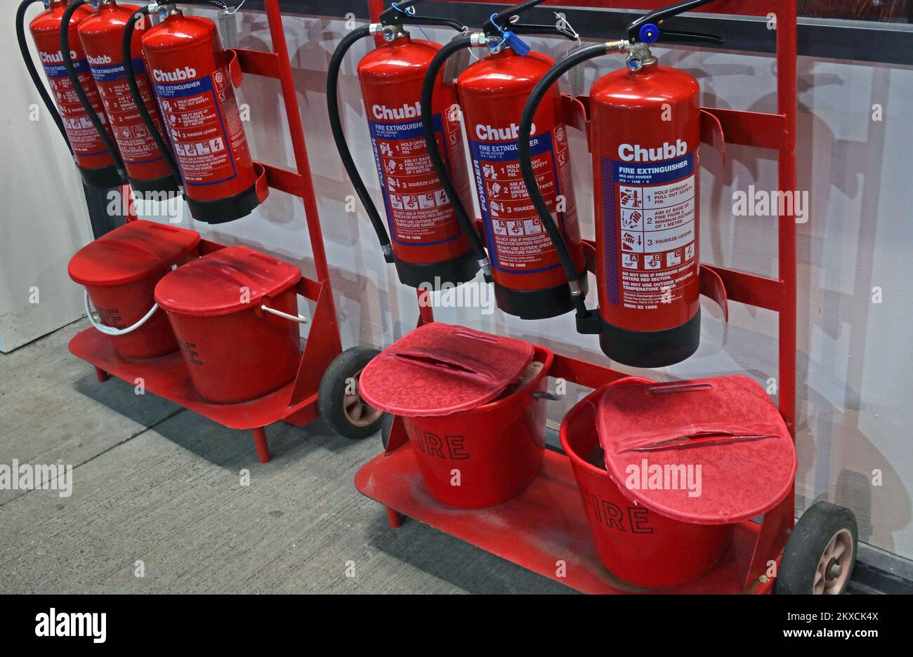 Chubb fire extinguishers and red fire buckets Stock Photo