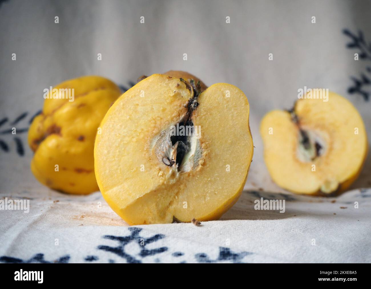 Half a quince standing on the abstract motifs. Stock Photo