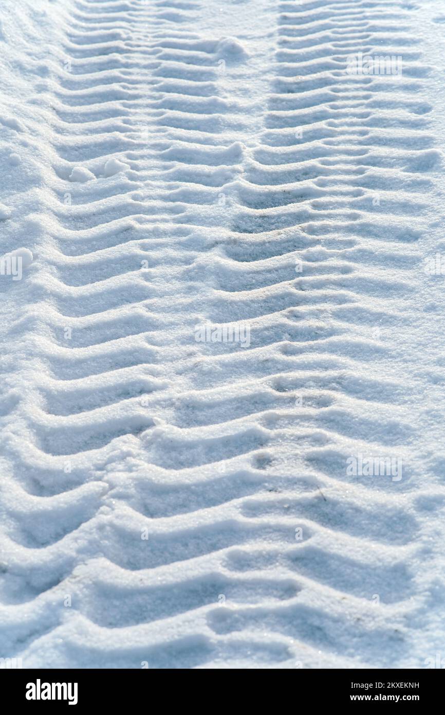 Winter tires Tire tracks on fresh snow. Pattern, imprint of tractor tire tread on snow. Top view