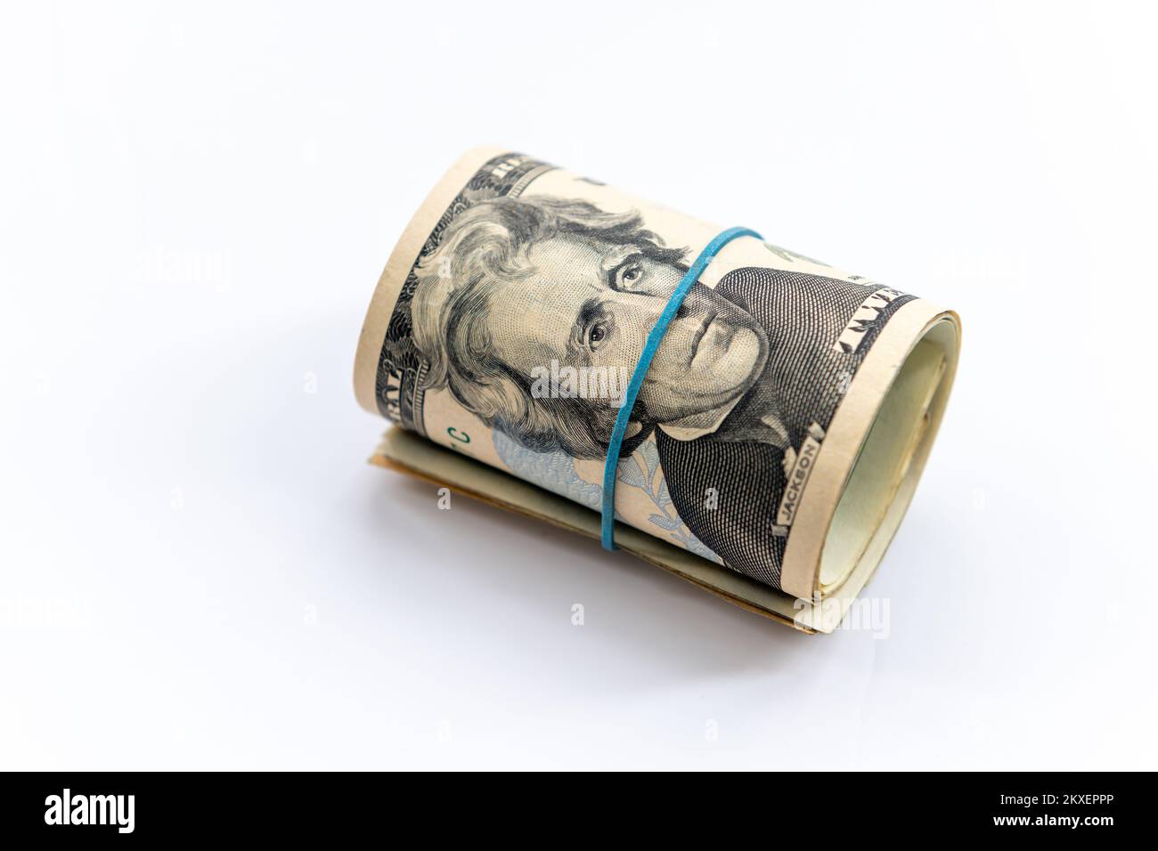 A roll up bundle of US dollar bills isolated in a white background. Stock Photo