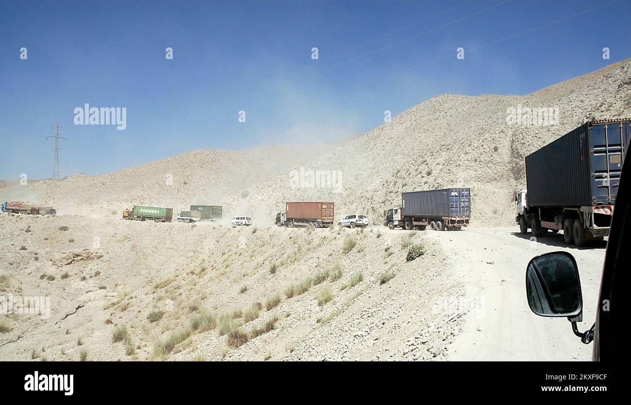 Road between Jalalabad and Kabul, Nangarhar Province / Afghanistan: Trucks on the dusty road between Jalalabad and Kabul in Afghanistan. Stock Photo