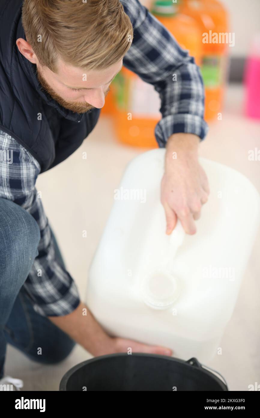 worker pour chemical into bucket Stock Photo Alamy
