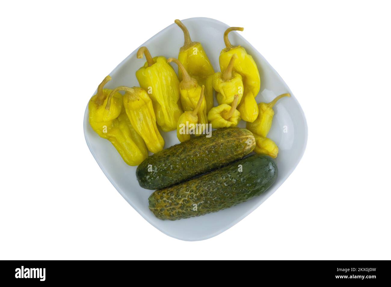 Pickled cucumbers and peppers on a plate isolated on a white background. Fermented vegetables home cooking. Stock Photo
