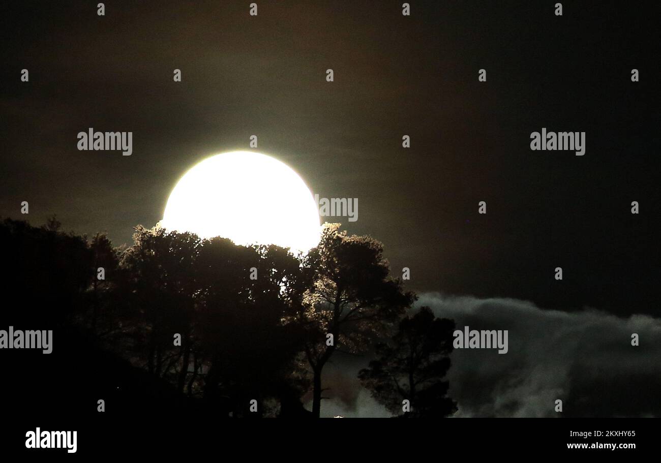 Photo taken on Oct. 1, 2020 shows the full moon above the city, in Sibenik, Croatia.A micro moon , as a contrary to a super moon, occurs when it rises at the furthest away point from the Earth.It normally appears amaller and slightly less bright.This Micro Harvest Moon will be the second asmallest of all in 2020. Photo: Dusko Jaramaz/PIXSELL  Stock Photo