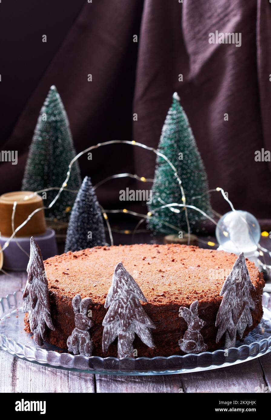 Chocolate honey cake in a Christmas decoration on a wooden background. Stock Photo