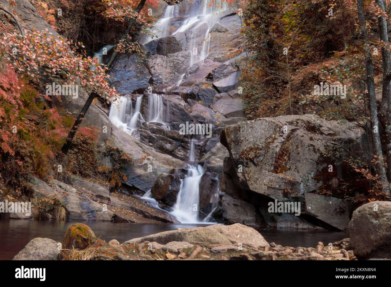 Cascada en la ruta de Las Nogaledas, Cáceres, España, con los colores rojizos del otoño Stock Photo