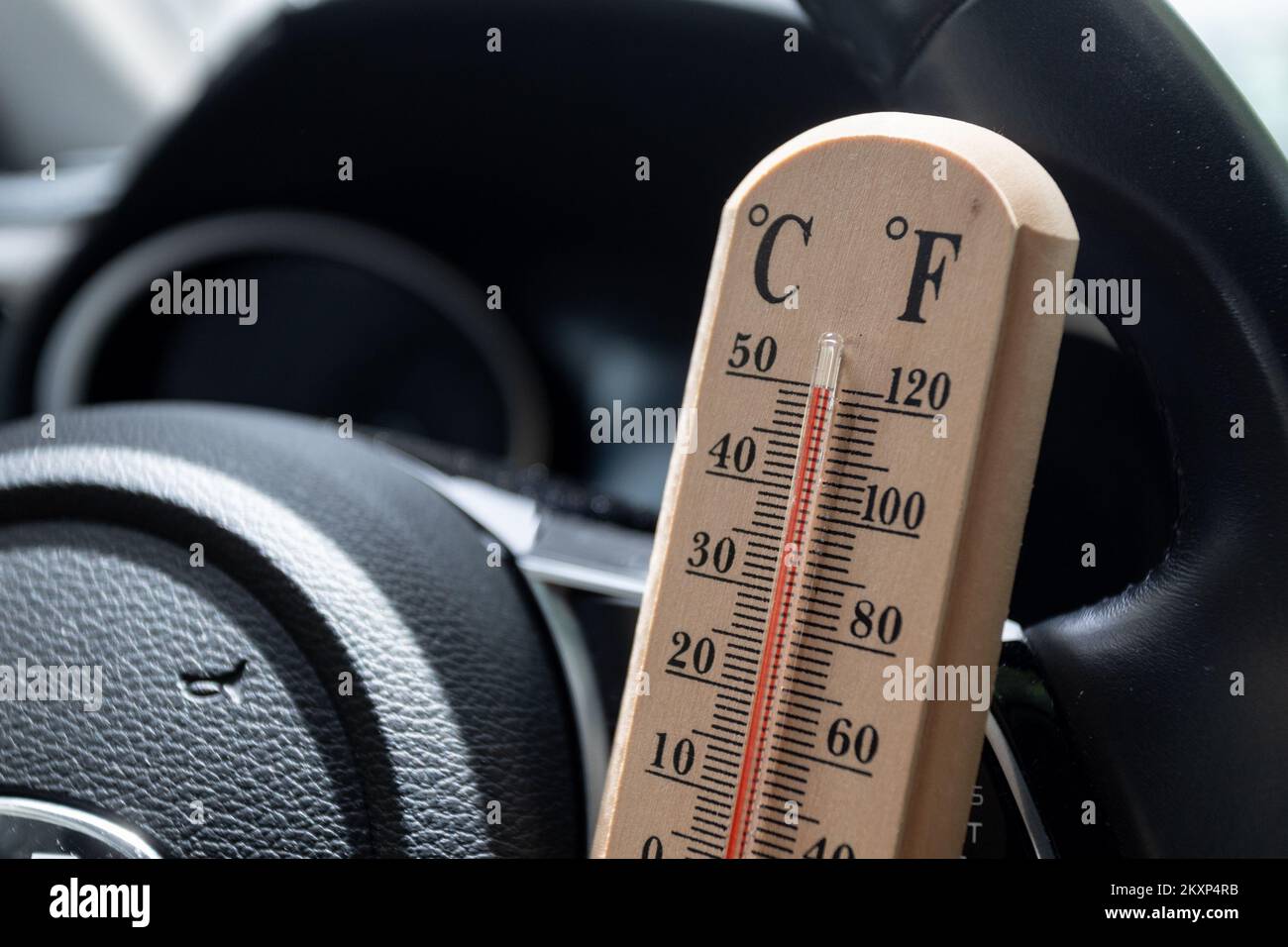 The thermometer placed in car shows temperatures reading above 100