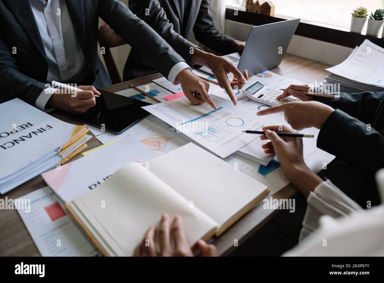 diverse coworkers working together in boardroom, brainstorming, discussing and analyzing and planning business strategy. Stock Photo