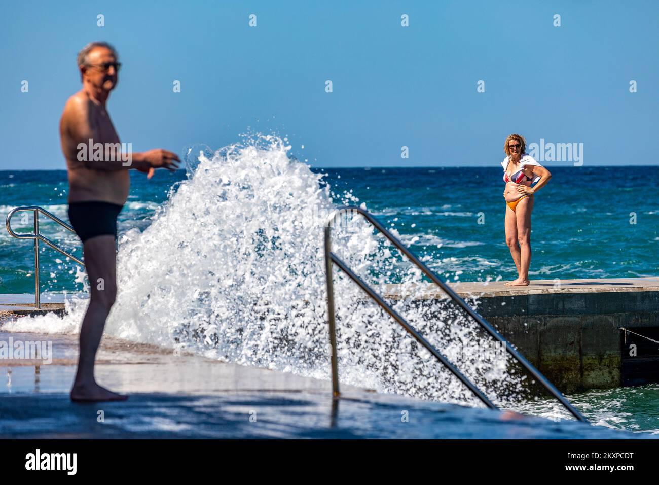 People enjoying high waves on Verudela Beach, in Pula, Croatia, on June