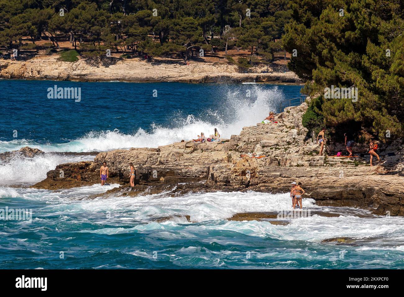 People enjoying high waves on Verudela Beach, in Pula, Croatia, on June
