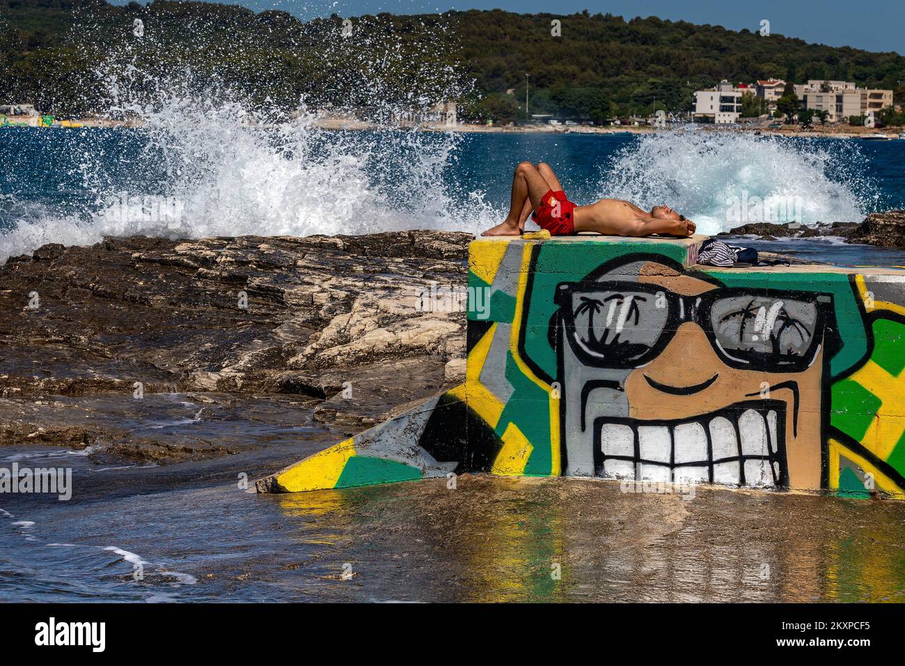People enjoying high waves on Verudela Beach, in Pula, Croatia, on June