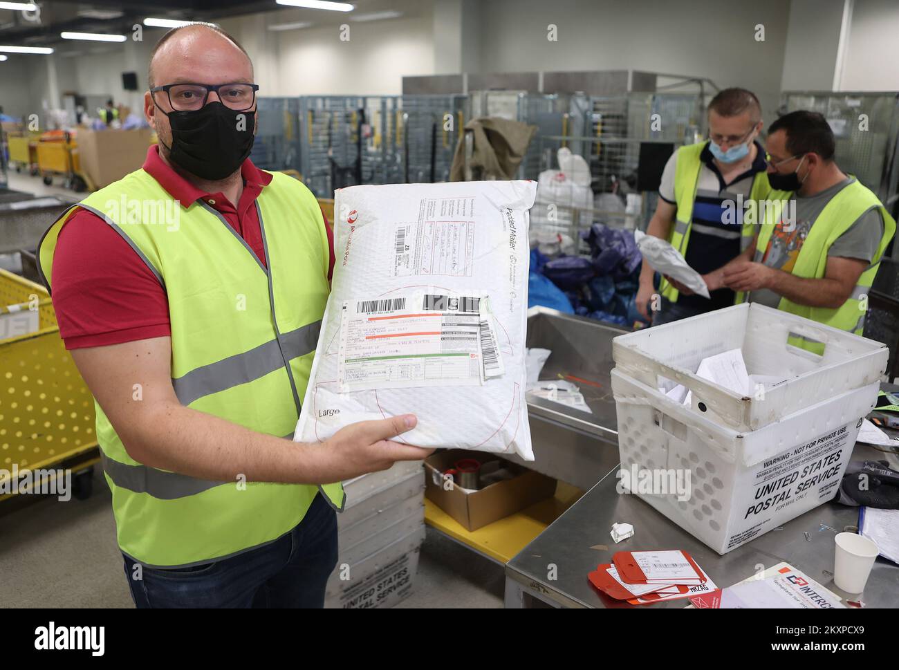 Postal workers are seen sorting packages at the Central Sorting Center