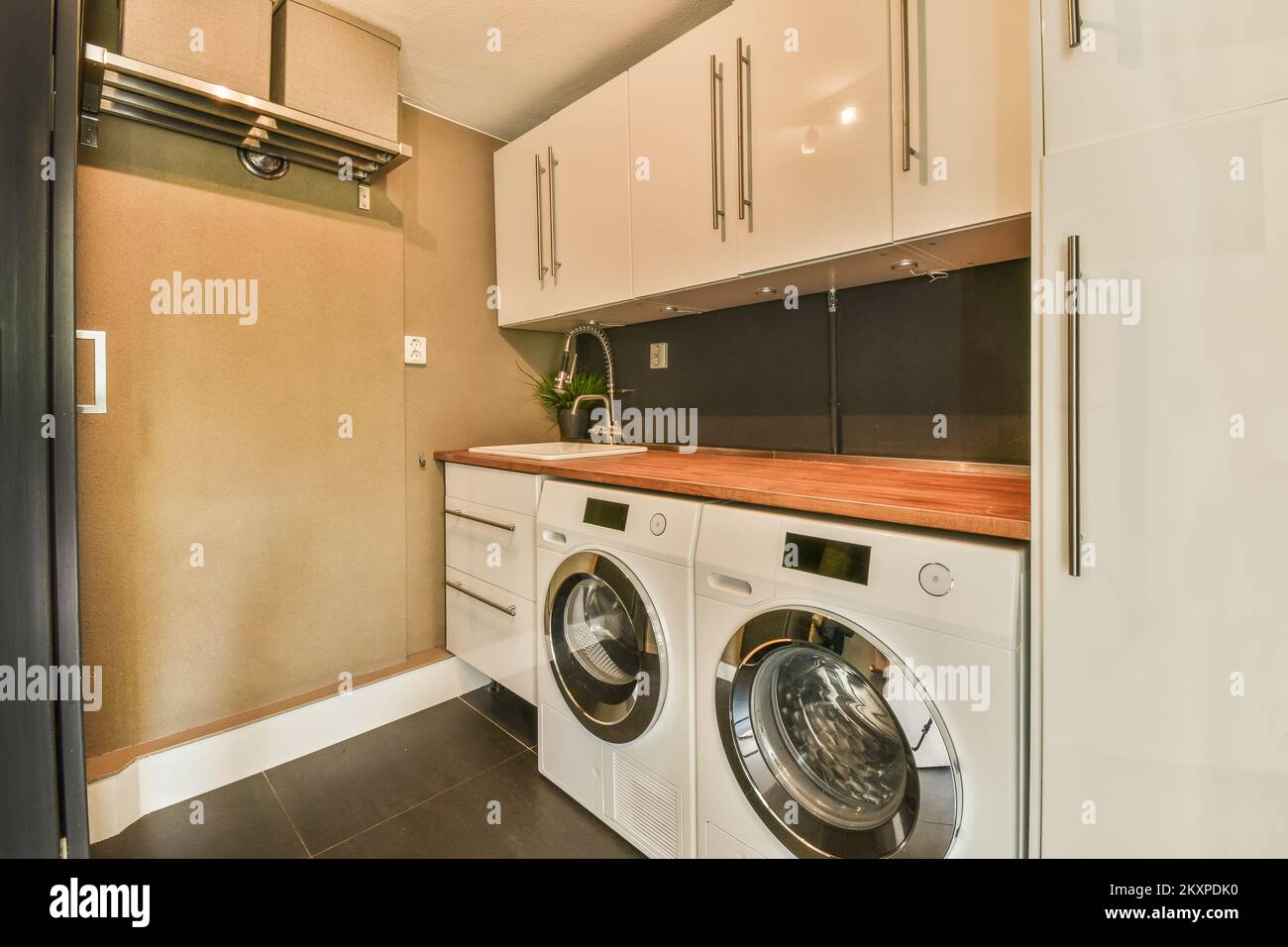 Laundry room interior. Utility room with washing machine, cleaning  equipment, home cleaners, clean wipes, hanging colorful shirts on  clothesline on wh Stock Photo - Alamy