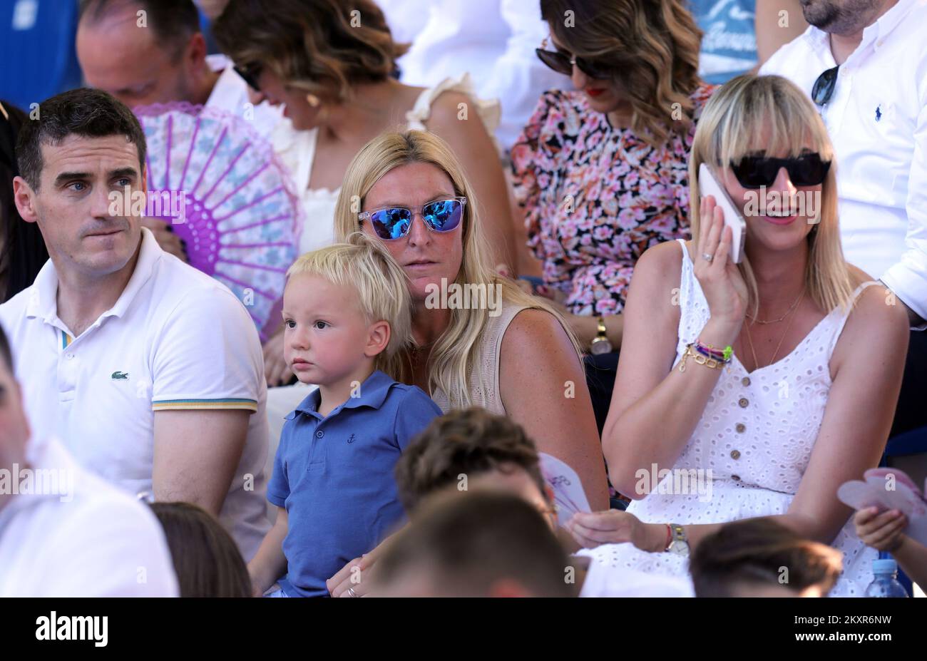A former Croatian alpine skier Janica Kostelic with her son in the audience during the famous knight's game Sinjska Alka that was held for the 306th time in Sinj on August 8, 2021. Alka is the last stage of the competition after Bara and Coja. Alka is a competition in which alkars ride horses to throw an alka spear. The Alkar competition is conducted in such a way that the Alkar on horseback in a full race spears a spear that hangs in the middle of a rope stretched horizontally between two pillars attached to the edges of the racetrack. Each alkar wears an antique knight's uniform in the most Stock Photo