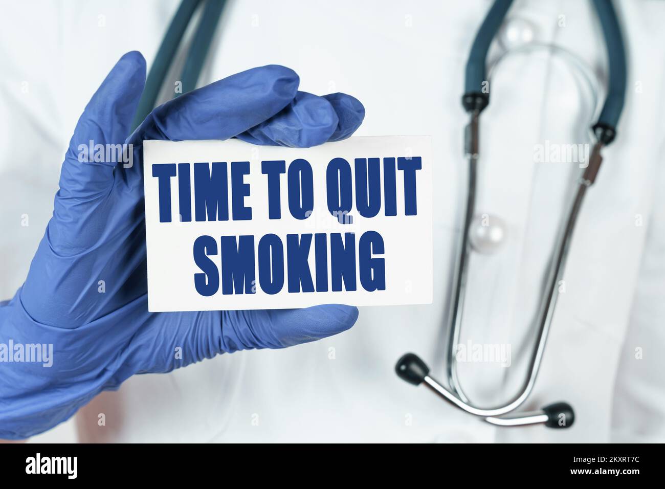 Medicine concept. The doctor holds a business card that says - TIME TO QUIT SMOKING Stock Photo