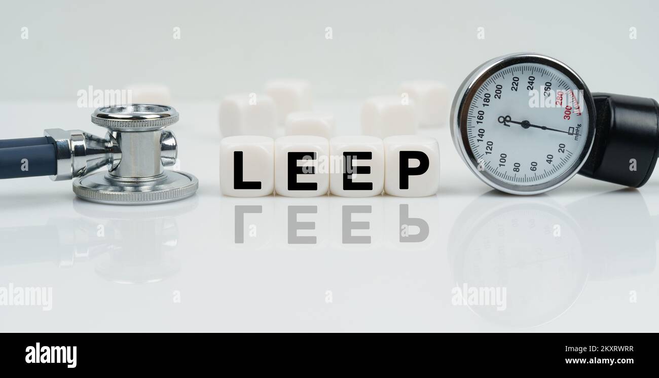 Medicine concept. On a reflective white surface lies a stethoscope and cubes with the inscription - LEEP Stock Photo