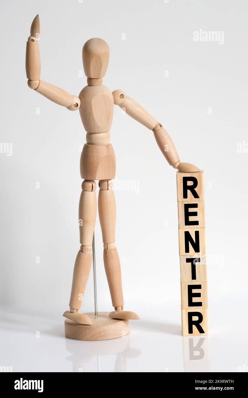 Business and medicine. The wooden man raised his hand, and under his left hand he has cubes with the inscription - RENTER Stock Photo