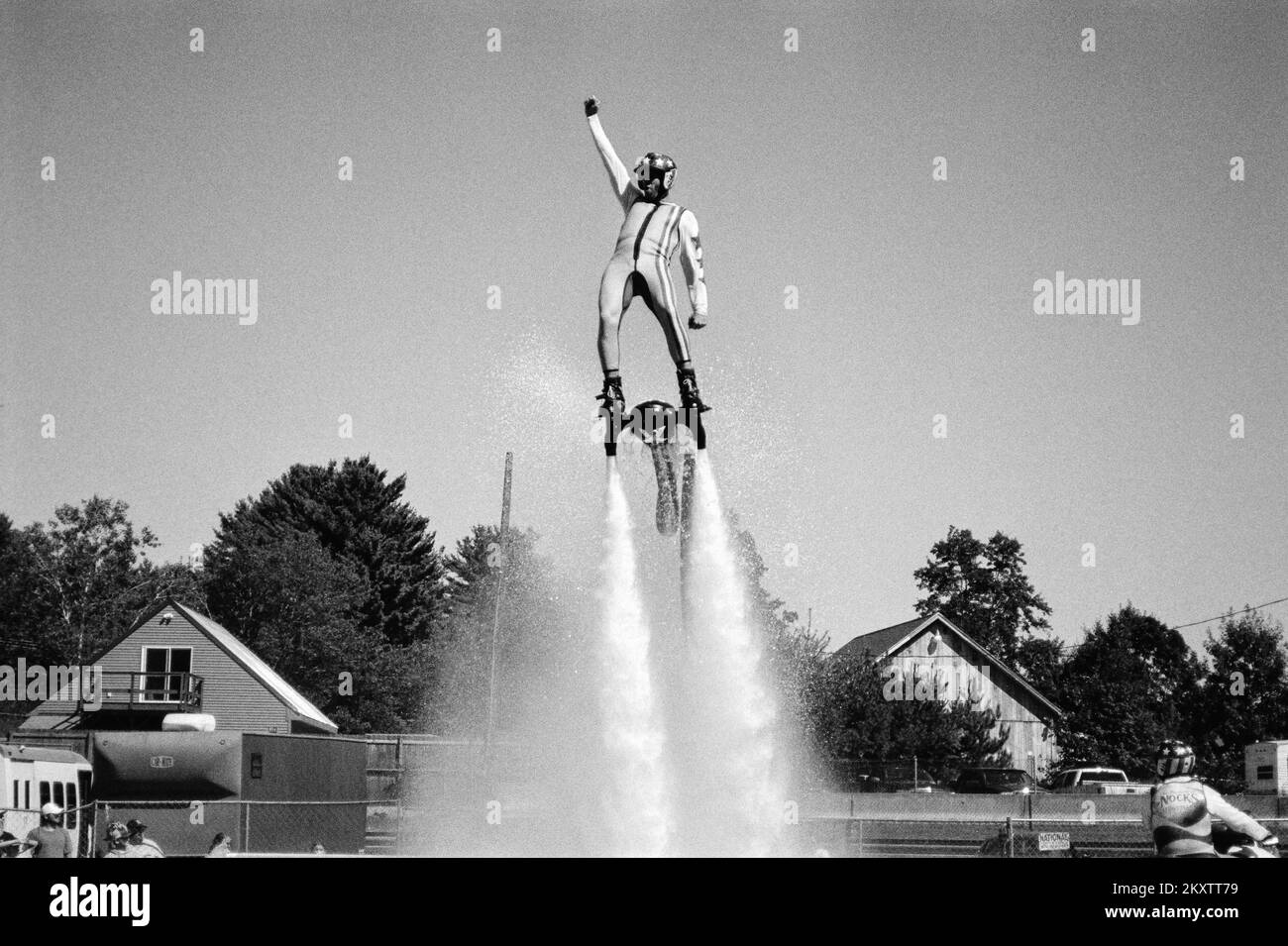 A Performer pilots a Jet Pack in a pool on a sunny day at the Hopkinton Fair. Hopkinton New Hampshire. The image was captured on analog black and whit Stock Photo