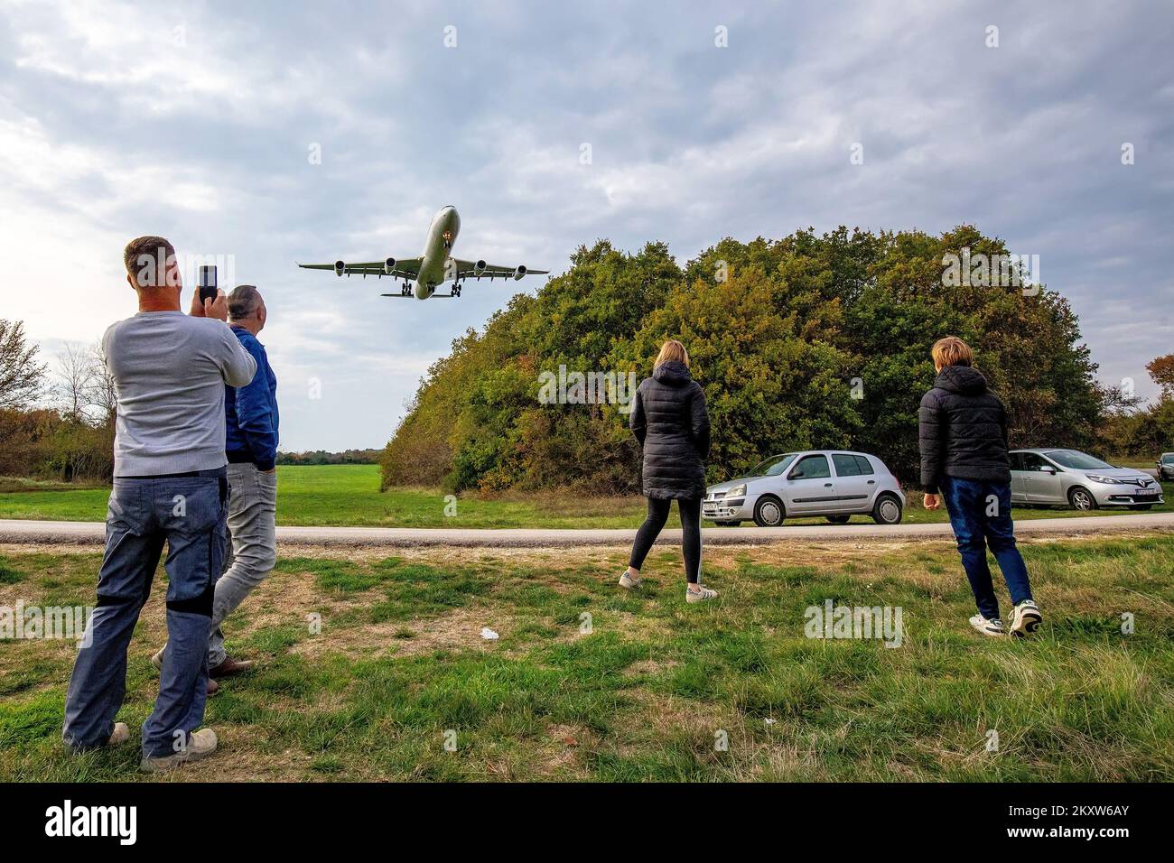 Citizens are watching the plane take off in Pula, Croatia on Nov. 16, 2021. The company Swiss International Air Lines on the type of aircraft Airbus A343 these days over Pula performs the tasks of flying or retraining of professional pilots on this type of aircraft. At the end of the runway, curious people from Pula come mostly with children and enjoy the planes that fly a few tens of meters above their heads when landing, although due to the size of the plane, the flight seems lower. Photo: Srecko Niketic/PIXSELL Stock Photo
