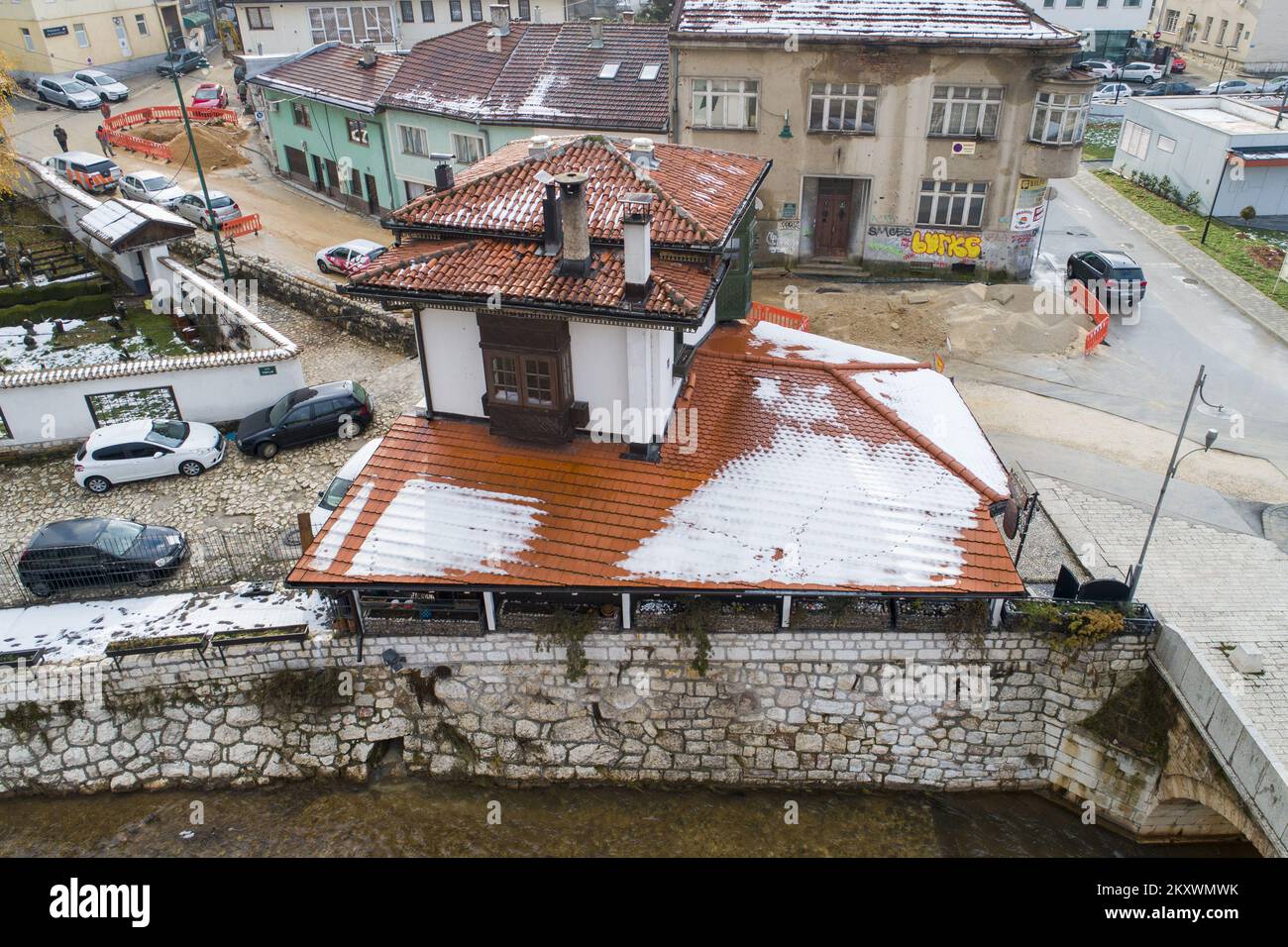A picture taken by a drone shows Inat house (Spite house). When the location of the construction of the City Hall in Sarajevo was determined, the Austro-Hungarian authorities decided that the construction required the demolition of two restaurants and one house. The owner of the house did not allow it to be demolished for any reason. So, after long negotiations, he asked to be paid in ducats and to move his house to the other side of the coast, brick by brick. They did it and it has been called Inat House (Spite House) ever since. Today it houses a famous restaurant., in Sarajevo, Bosnia and H Stock Photo