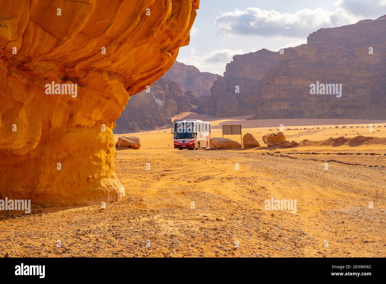 Tourist bus arriving at a camp site with the mountains of wadi Rum Jordan. In the early morning. Stock Photo