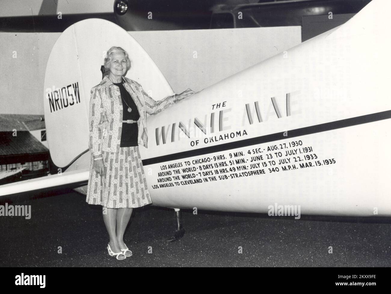 Fay Gillis Wells, writer, broadcaster, foreign correspondent, sailor, designer of boat interiors and noted aviatrix, stands in the National Air and Space Museum beside the Winnie Mae. This is the plane in which Wiley Post made his record-breaking global flight in 1933. Fay Wells participated in Posts achievement by managing the fuel dumps for the Winnie Mae in Siberia and by providing Wiley Post with the maps and navigation data. These services contributed to the success of the flight by which Post broke his own global record of 1931. Date 1976 Stock Photo