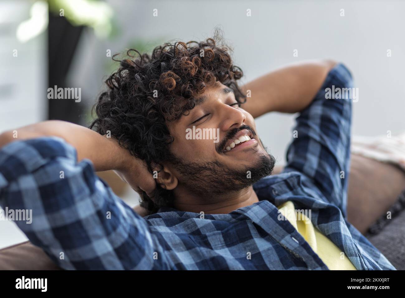 Relax at home, positive thinking concept. Portrait of happy asian man lying on sofa resting Stock Photo