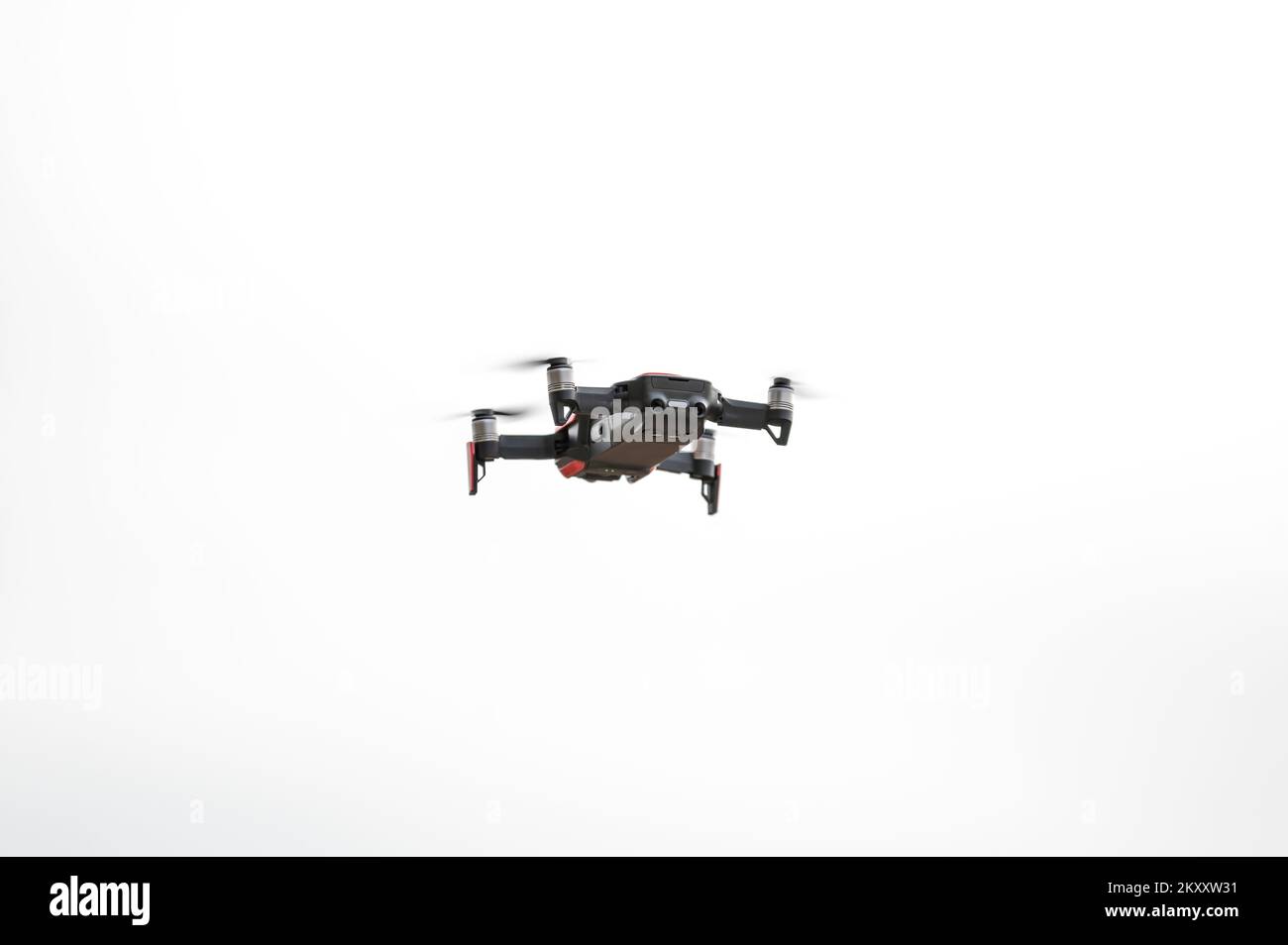 Quadcopter drone flying in a clear sky with the propellers spinning at