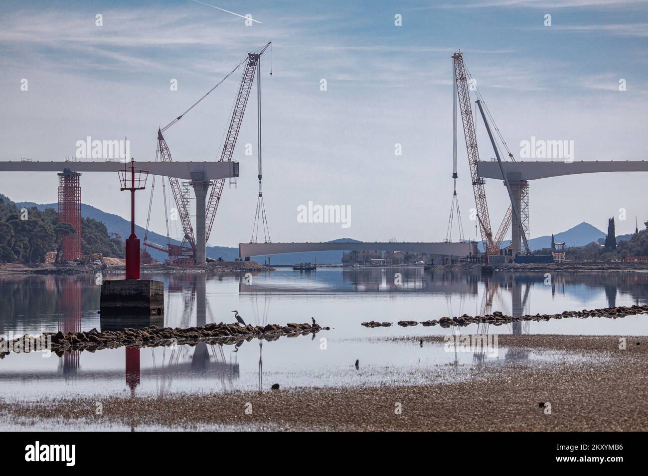 Preparations for the installation of the last segment of the steel span structure of the Ston bridge as part of The South Dalmatia Road Connectivity project, on March 15, 2022, in Broce, near Ston, Croatia. The project consists of the construction of a 32.5 km alternative road entirely within Croatia to bypass the two border crossings with Bosnia and Herzegovina (BiH) to cross the BiH Neum coastal land strip. The project includes the 2.4 km long Peljesac bridge and also 12 km of access roads, the improvement of 10.2 km of the existing D414 road and the construction of a 7.9 km bypass around th Stock Photo