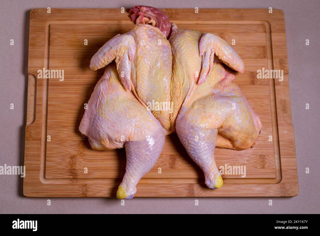 Raw whole chicken on wooden board. chicken tobacco. Close-up. Stock Photo