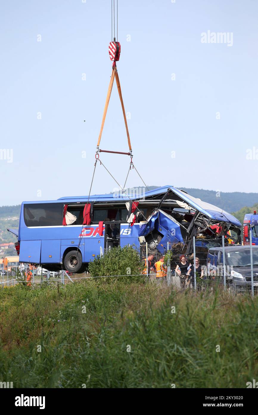 A crane works on removing the bus with Polish licence plates that slipped off a road, from the scene near Varazdin, northwestern Croatia, August 6, 2022. At least 12 people died and 31 injured after a Polish bus filled with religious pilgrims skidded off a highway in northern Croatia early on Saturday morning. 18 people among the 31 hurt have suffered serious injuries after the bus crashed off the A4 highway in Podvorec, about 30 miles (50km) north of capital Zagreb. Photo: Matija Habljak/PIXSELL Stock Photo