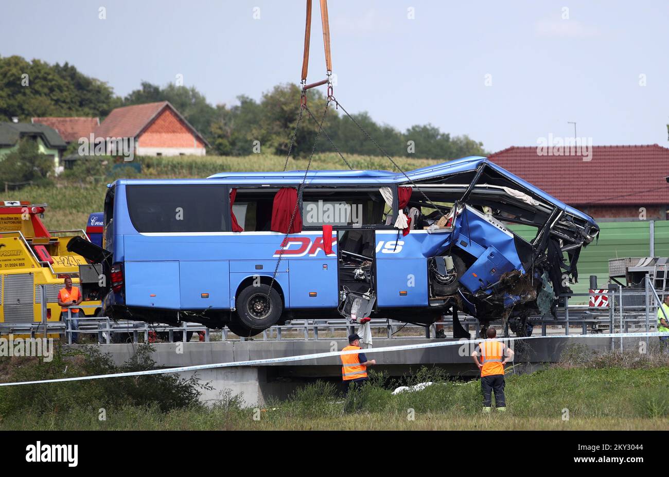 A crane works on removing the bus with Polish licence plates that slipped off a road, from the scene near Varazdin, northwestern Croatia, August 6, 2022. At least 12 people died and 31 injured after a Polish bus filled with religious pilgrims skidded off a highway in northern Croatia early on Saturday morning. 18 people among the 31 hurt have suffered serious injuries after the bus crashed off the A4 highway in Podvorec, about 30 miles (50km) north of capital Zagreb. Photo: Zeljko Lukunic/PIXSELL Stock Photo